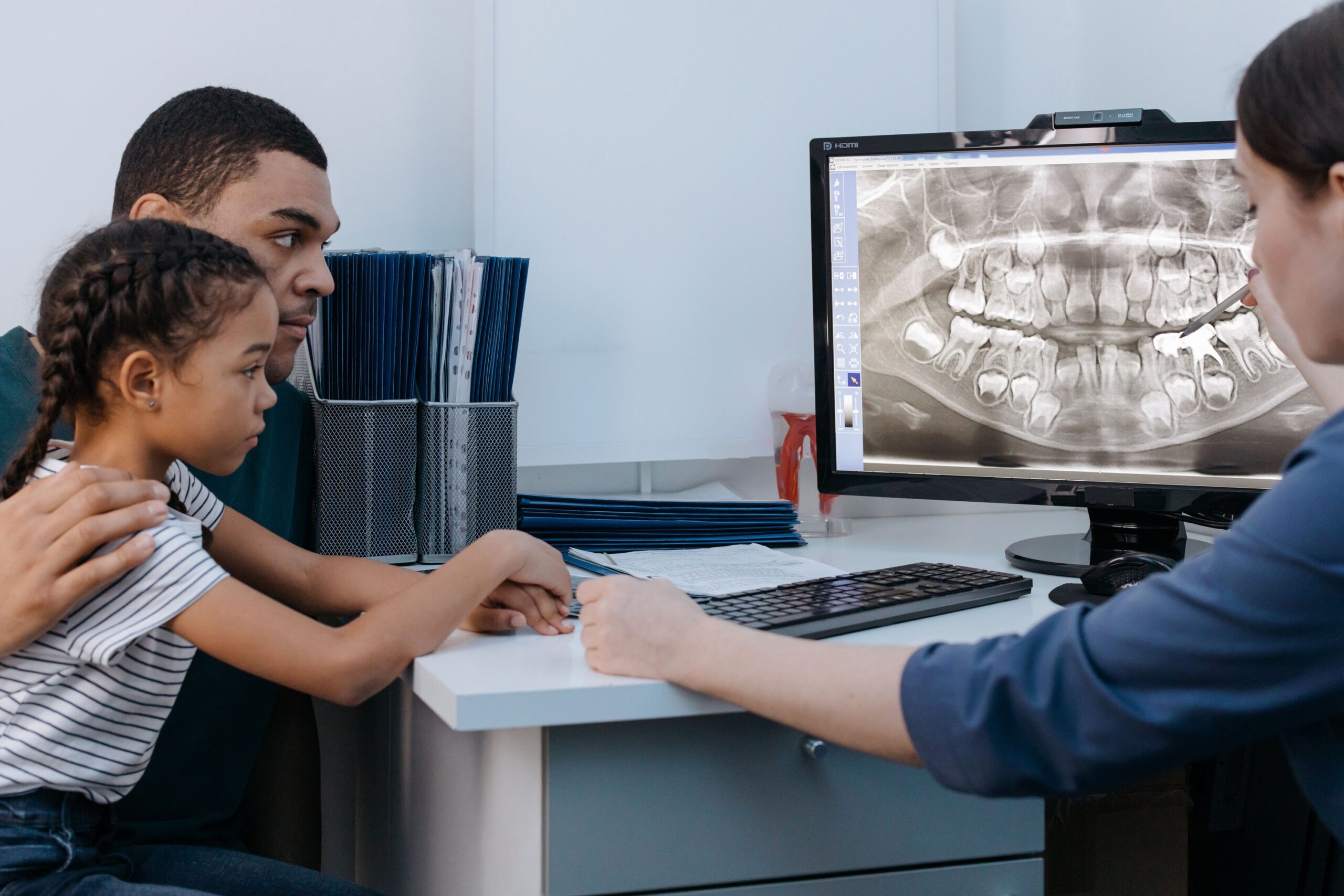 Parent and child reviewing dental X-rays with a dental professional
